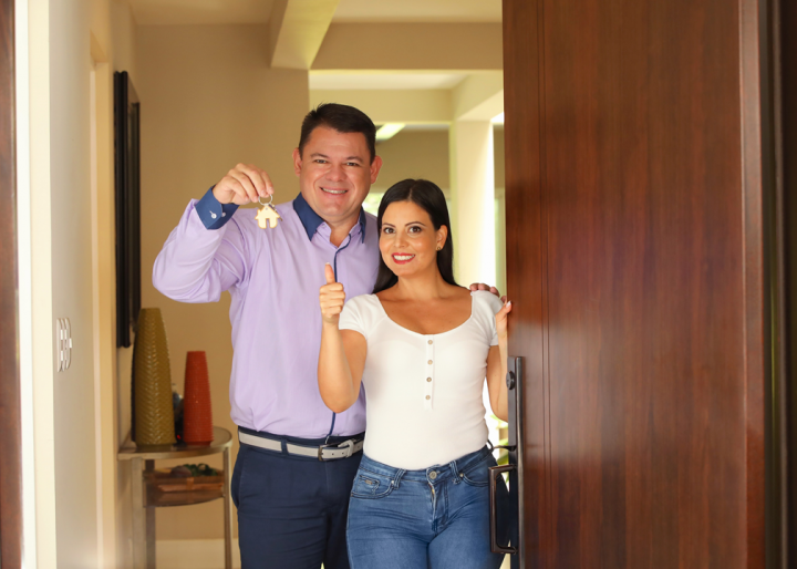 Pareja con unas llaves en la puerta de su nueva casa